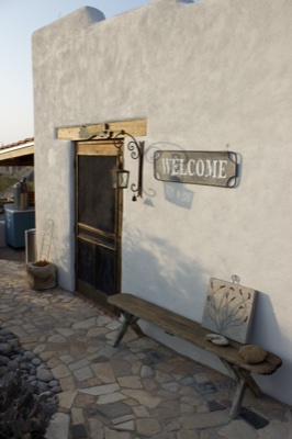 Rustic adobe house entrance with bench