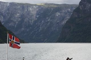 Norwegian Flag Over Fjord Mountains