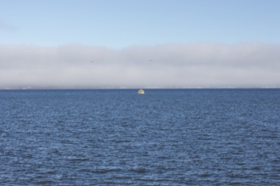 Small Boat on Foggy Sea Horizon