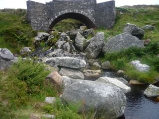 Stone arch bridge over rocky stream