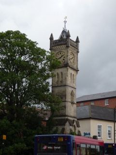 Stone clock tower with bus below