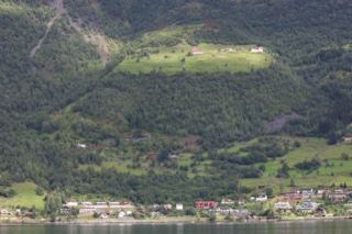 Mountain Village Nestled in Green Fjord Valley