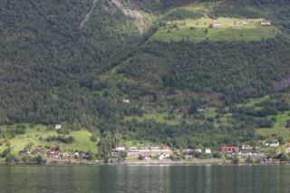 Fjord Village Beneath Forested Mountains