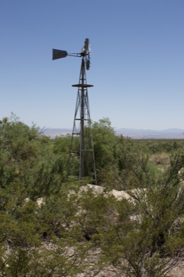 Windmill in Desert Scrub Landscape