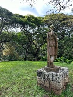 Weathered Statue in Lush Garden