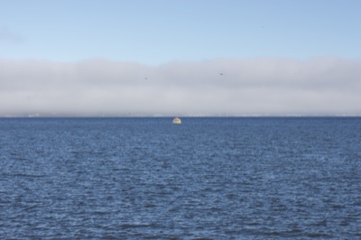 Distant Boat on Foggy Ocean Horizon