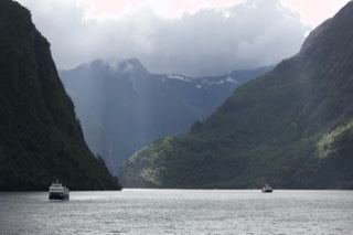Fjord Mountains With Boats Under Cloudy Sky